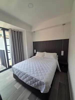 a bedroom with a large bed and a large window at Beautiful Laureles Studio Apartment in Medellín