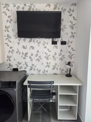 a desk with a television on a wall with a printer at Beautiful Laureles Studio Apartment in Medellín