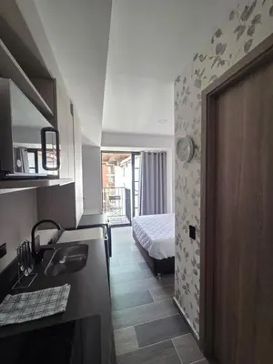 a room with a bed and a bathroom with a sink at Beautiful Laureles Studio Apartment in Medellín