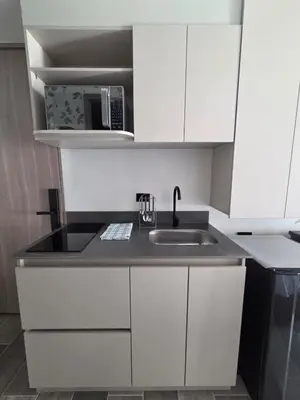 a white kitchen with a sink and a microwave at Beautiful Laureles Studio Apartment in Medellín