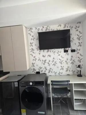 a kitchen with a dishwasher and a tv on the wall at Beautiful Laureles Studio Apartment in Medellín