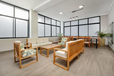 a waiting room with chairs and tables and windows at Ph volcana in Medellín