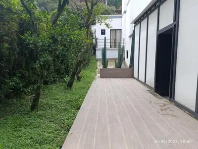 a wooden walkway next to a white building at Ph volcana in Medellín