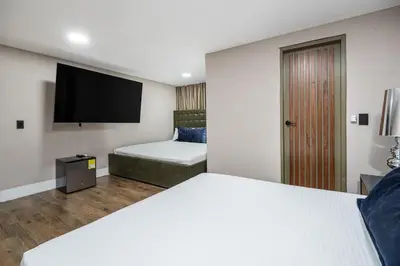 a hotel room with a bed and a flat screen tv at Ph volcana in Medellín