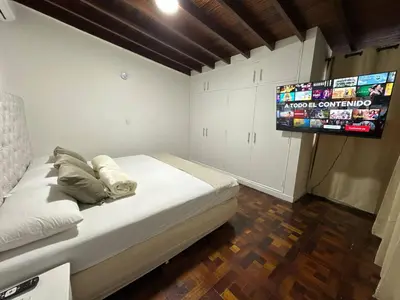 a bedroom with a bed and a flat screen tv at Group stay 21 guests, WiFi 900 Mb in Medellín