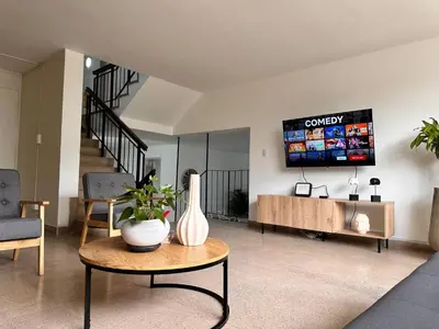 a living room with a table and a tv on the wall at Group stay 21 guests, WiFi 900 Mb in Medellín