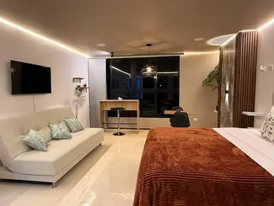 a bedroom with a bed and a couch and a tv at Modern and cozy apartment - Laureles Estadio in Medellín