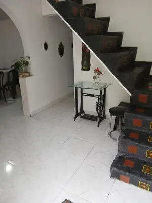 a room with a table and stairs in a house at Casa grande con terraza in Manizales