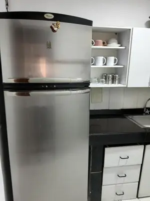 a stainless steel refrigerator in a kitchen with white cabinets at Casa grande con terraza in Manizales
