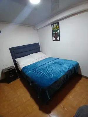 a bedroom with a large bed with a blue blanket at Casa grande con terraza in Manizales
