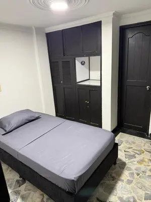 a bedroom with a bed with black cabinets and a bed sidx sidx sidx at Tu alojamiento parque caldas in Manizales