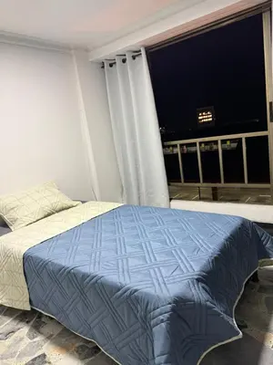 a bedroom with a bed and a large window at Tu alojamiento parque caldas in Manizales