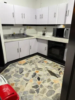 a kitchen with white cabinets and a stone floor at Tu alojamiento parque caldas in Manizales