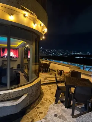 a patio with tables and chairs on a roof at night at Tu alojamiento parque caldas in Manizales