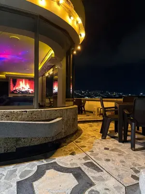 a patio with tables and chairs on a roof at night at Tu alojamiento parque caldas in Manizales