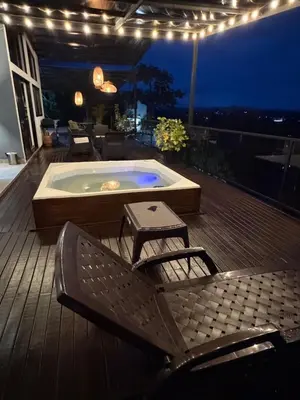 a deck with a jacuzzi tub and two chairs at Casa Finca en Guatapé in Guatapé
