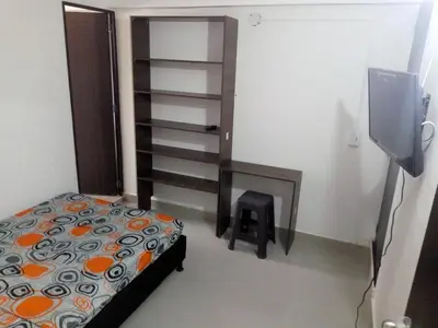 a small bedroom with a bed and a stair case at VILLA La May in Medellín