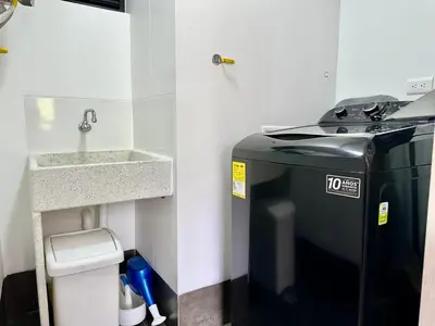 a small bathroom with a sink and a refrigerator at GRAND medellin in Medellín