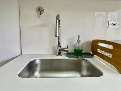 a kitchen sink with a green bottle on it at GRAND medellin in Medellín