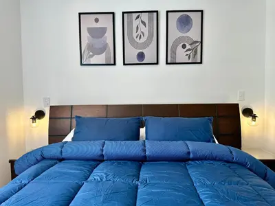 a large blue bed with four pictures on the wall at GRAND medellin in Medellín