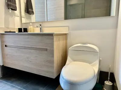 a bathroom with a white toilet and a sink at GRAND medellin in Medellín