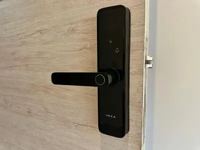 a black door handle on a wooden door at GRAND medellin in Medellín