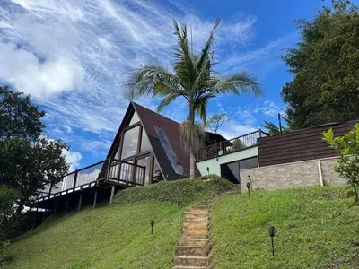 a house on top of a hill with a palm tree at Finca Hotel Mariangel in El Peñol