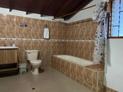 a bathroom with a tub and a toilet and a sink at Finca Hotel Mariangel in El Peñol
