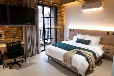 a bedroom with a bed and a desk and a television at Estrena Apto Moderno para Viajeros con Estilo in Medellín
