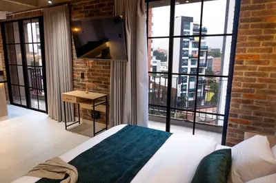 a bedroom with a bed and a large window at Estrena Apto Moderno para Viajeros con Estilo in Medellín