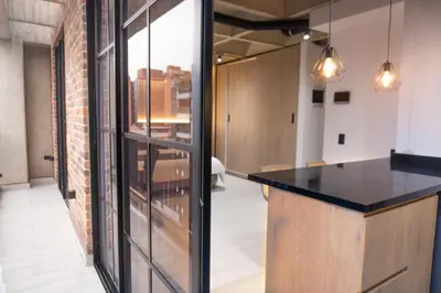 a kitchen with a black counter and a brick wall at Estrena Apto Moderno para Viajeros con Estilo in Medellín