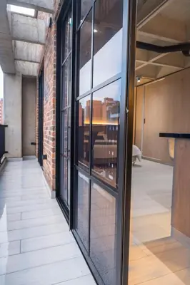an empty hallway with glass windows in a building at Estrena Apto Moderno para Viajeros con Estilo in Medellín