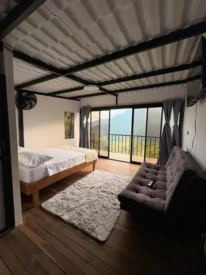 a bedroom with a bed and a couch and a window at Chocochucho Agroecoturismo in Amalfi