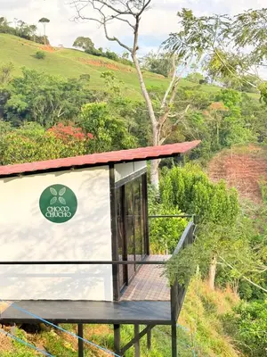 a tiny house with a wooden deck on a hill at Chocochucho Agroecoturismo in Amalfi