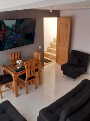 a living room with a dining room table and chairs at Apartamento el descanso in Medellín