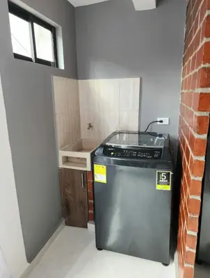 a small kitchen with a stove and a brick wall at Apartamento el descanso in Medellín