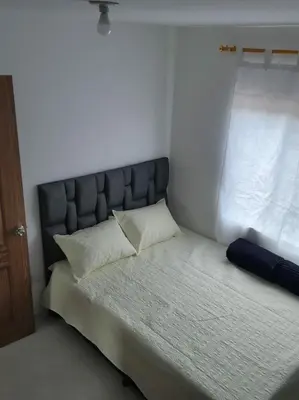 a bedroom with a bed with a headboard and a window at Apartamento el descanso in Medellín