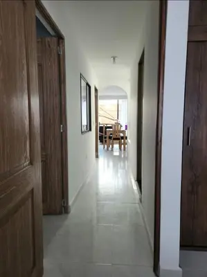 a hallway with wooden doors and a dining room at Apartamento el descanso in Medellín