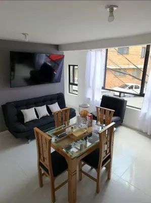 a living room with a glass table and chairs at Apartamento el descanso in Medellín
