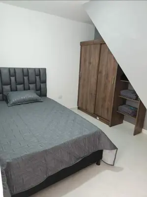 a bedroom with a bed and a wooden cabinet at Apartamento el descanso in Medellín