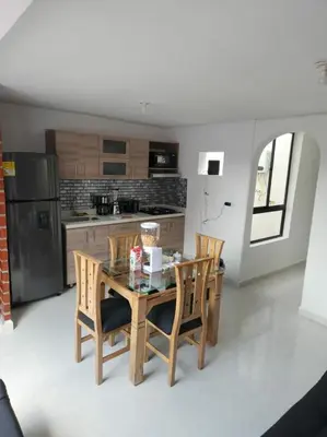 a kitchen with a table and chairs and a refrigerator at Apartamento el descanso in Medellín