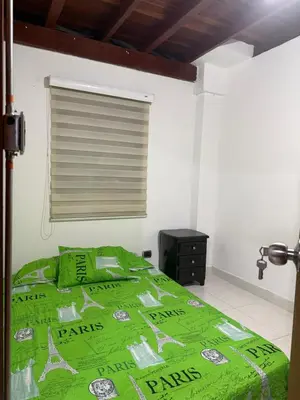 a bedroom with a green comforter on a bed at Apartamento Comuna 13 in Medellín