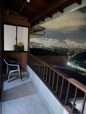 a chair on a balcony with a view of the city at Apartamento Comuna 13 in Medellín