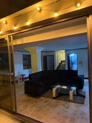 a living room with a black couch and a glass table at Tu alojamiento parque caldas in Manizales