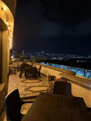 a patio with tables and chairs on a balcony at night at Tu alojamiento parque caldas in Manizales