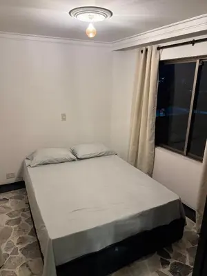 a bed in a room with a window at Lu alojamiento parque caldas in Manizales