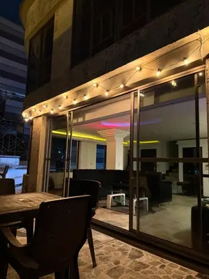 a patio with a table and chairs and lights at Lu alojamiento parque caldas in Manizales