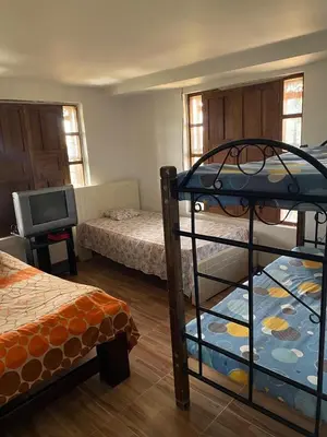 a bedroom with two bunk beds and a television at Casa Finca en el Peñol in Piedra El Marcial