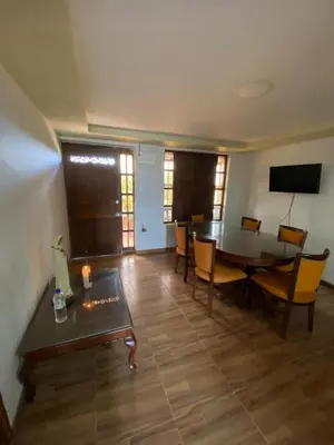 a living room with a table and chairs and a television at Casa Finca en el Peñol in Piedra El Marcial