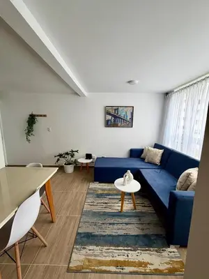 a living room with a blue couch and a rug at Apartamento en Manizales Montaña & Café in Estación El Salto
